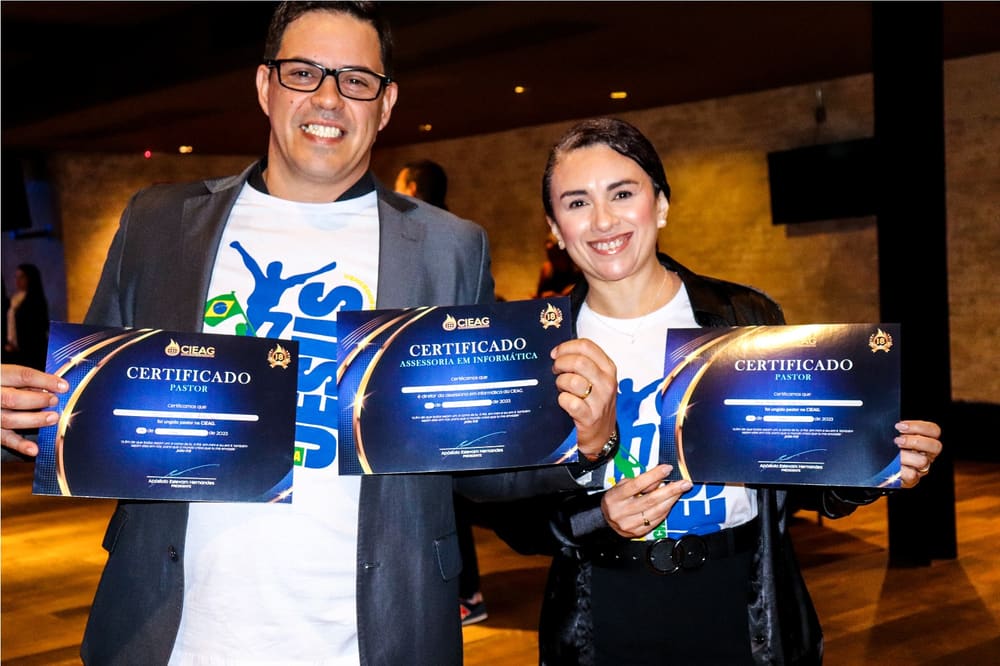 Pr. German Yaku e Pra. Patrícia Yakubisin sorrindo, cada um segurando o certificado de consagração pastoral da CIEAG.