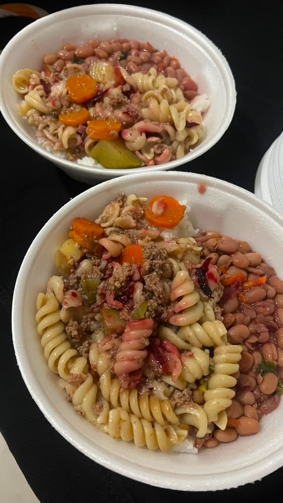 Duas marmitas abertas com arroz, feijão, macarrão com carne moída e legumes.