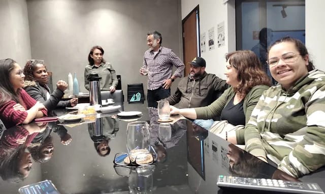 Voluntários da Infinito Amor em volta da mesa, conversando na Noite dos Voluntários.